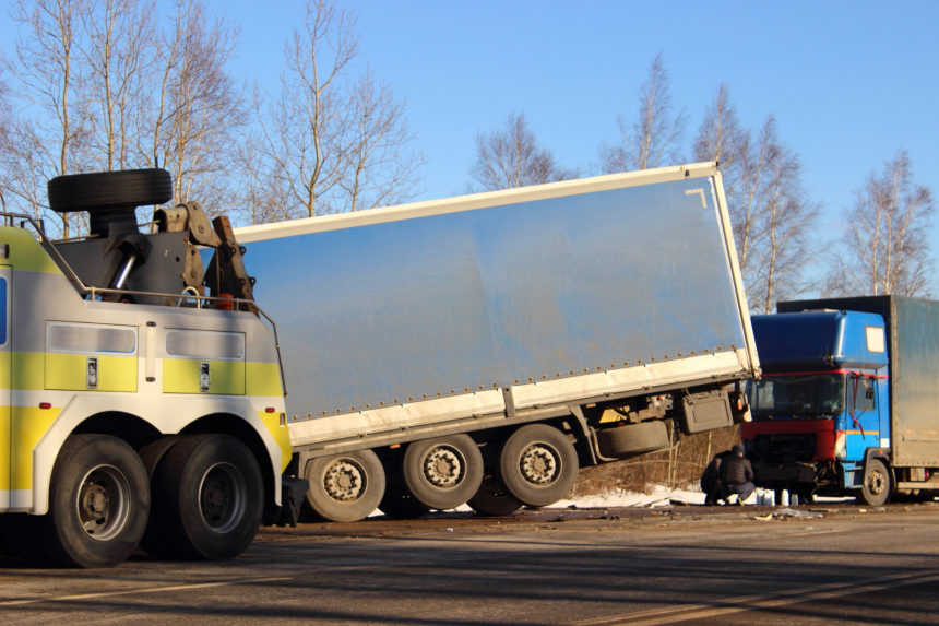 Wrecked truck rescue from roadside ditch on spring day, cargo road accident