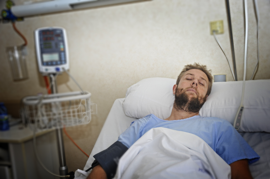 young injured man lying in bed hospital room resting from pain looking in bad health condition after suffering accident in health care concept