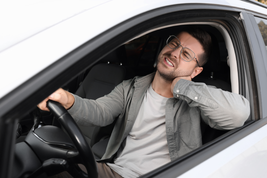 Man suffering from neck pain in car
