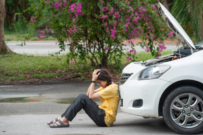 Young stressed woman having trouble with her car breakdown on the road and she waiting someone can help her.