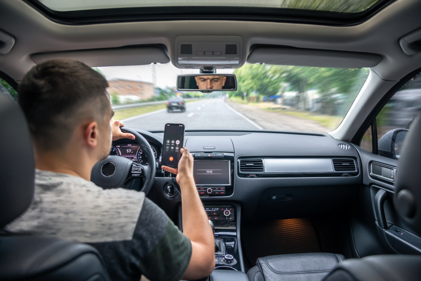 Businessman talking on cell phone while driving.