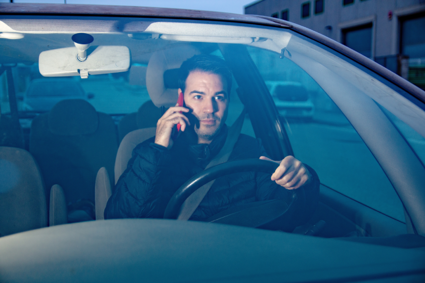 Driver distracted using mobile phone while driving car
