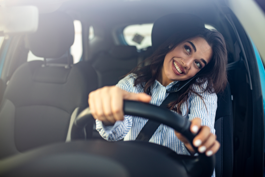 Businesswoman driving car and talking on cell phone concentrating on the road.