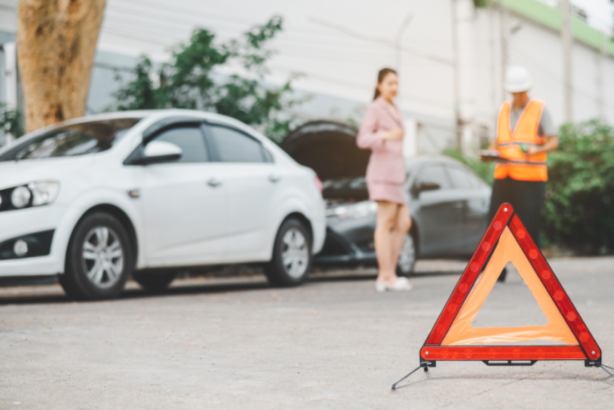 red emergency triangle on the road indicates that there is an accident or car breakdown on the road ahead.