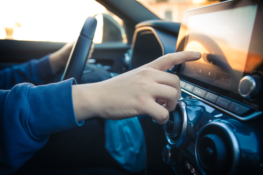 Teen drive a car and use infotainment. Young man reading messages and make phone call while driving.