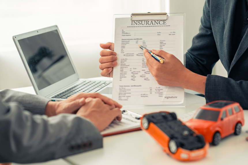 Insurance agent's hand protecting red toy car on table. Planning to manage transportation finance cost. Car insurance business concept.