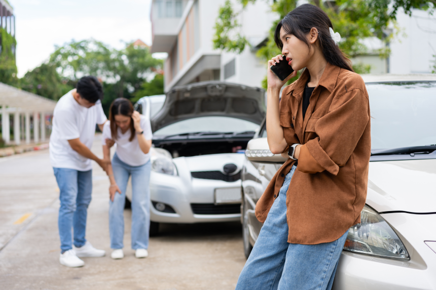 Car Accident Emergency, while another person tends to a passenger with an injury