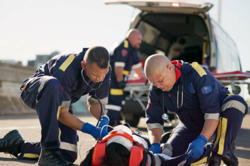 Paramedic, emergency and ambulance on road from car crash accident with healthcare, men and first aid. Patient, injury and medical help with rescue service with stretcher for transport to clinic