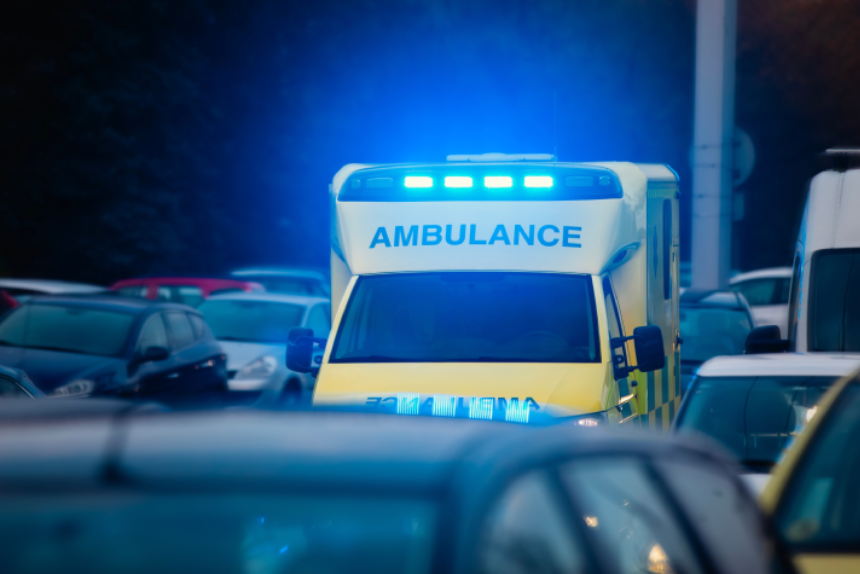 Fast moving ambulance car of emergency medical service on busy city street. Themes health care, rescue and urgency.