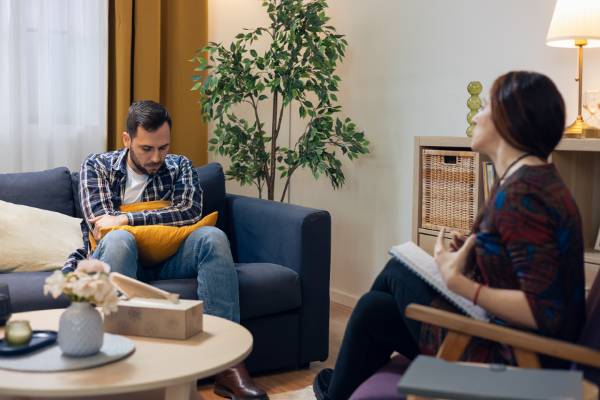 Man feeling sad during a counseling session with a female psychologist