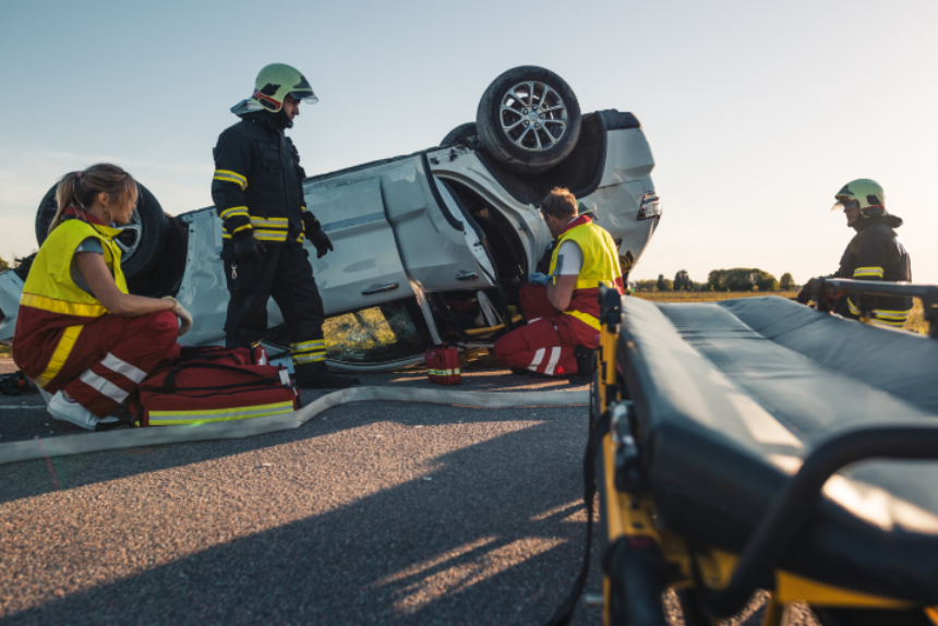 On the Car Crash Traffic Accident Scene: Paramedics and Firefighters Rescue Injured Victim Trapped in the Vehicle.