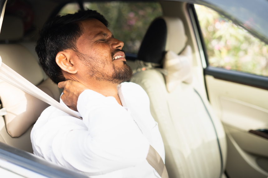Tired young indian cab driver suffering from neck joint pain due to over driving - concept of arthritis, unhealthy lifestyle, overworked and exhusted