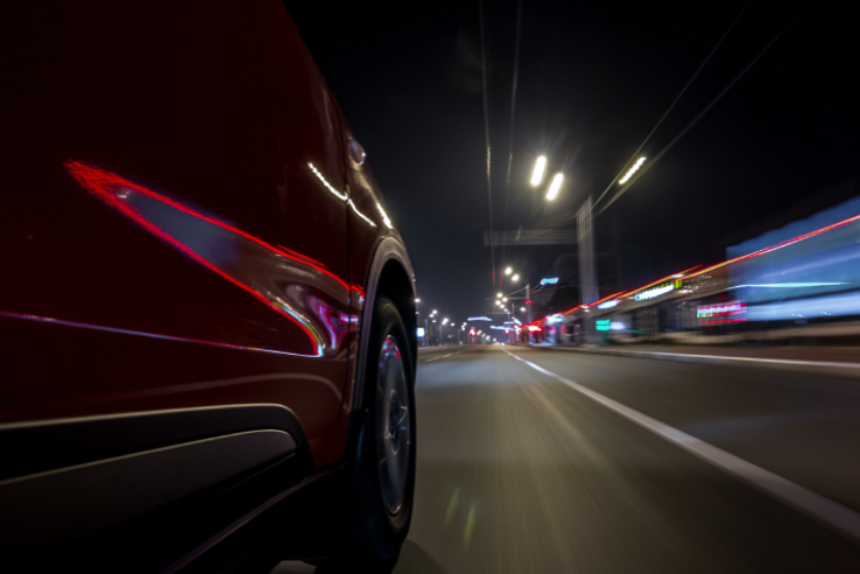 Drivelapse urban look from fast driving car at a night avenue in a city timelapse hyperlapse, road with lights reflected on car at high speed. Rapid rhythm of a modern city.
