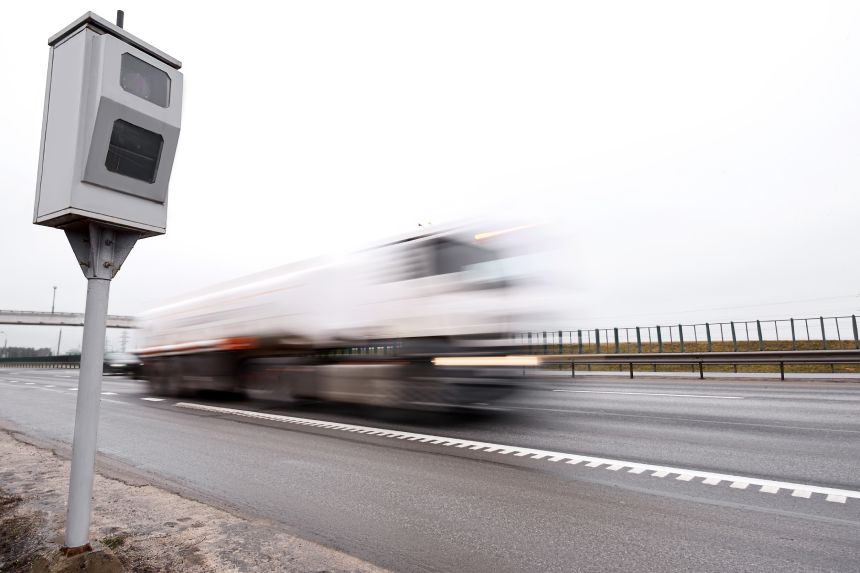 Police radar for measuring speed of passing vehicles stands on highway. Radar installed on roadside to control speed limit.