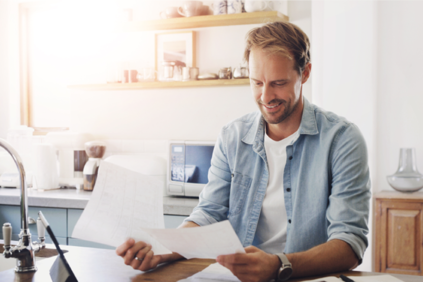 Man, tablet and happy with documents in home for mortgage bill payment, budget savings and debt free.