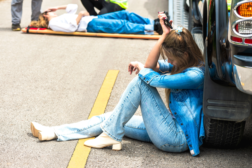 Young woman sitting and feeling depress with car accident and hitting pedestrian woman on road
