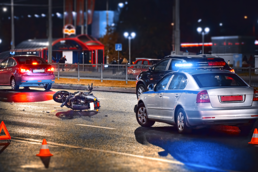 Moto bike collision at night. Motorcycle crash, night accident. Traffic police car with blue flashing lights investigate moto collision