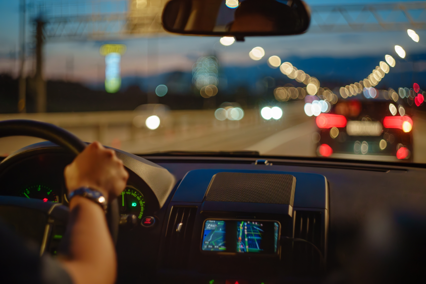 Driving car inside view. Man is holding steering wheel on highway