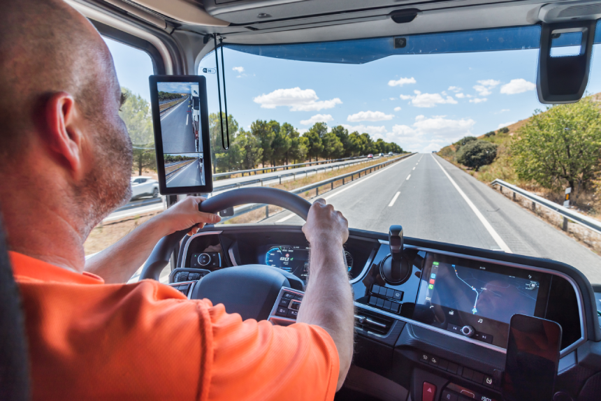 Truck driver driving on a straight highway, concentrating on driving.